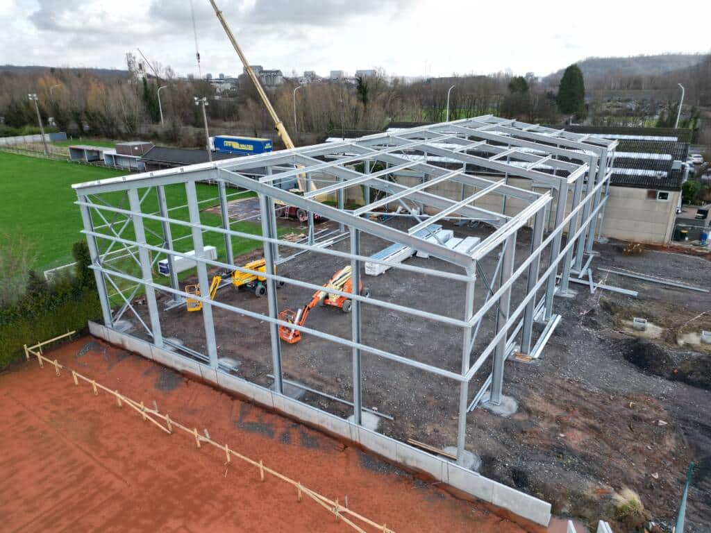 Ossature métallique ModuHome de la gamme ModuHall en montage au sol, préparation des murs et portiques.