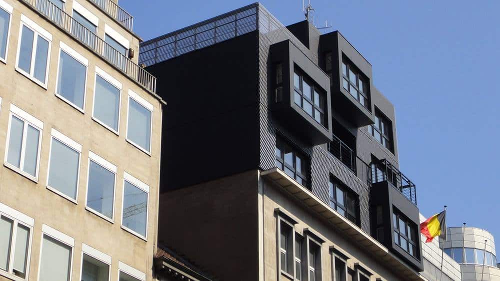 Rehausse ModuHome en façade noire sur bâtiment urbain existant.