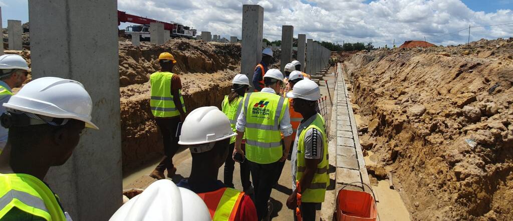 Équipe ModuHome en briefing chantier autour des fondations d’un bâtiment.