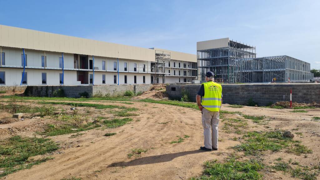 Suivi de chantier ModuHome devant bâtiment en ossature métallique.