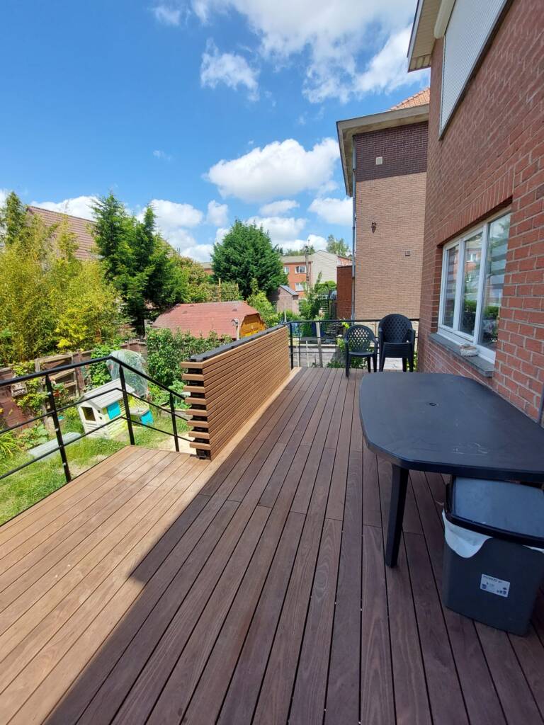Terrasse ModuHome finie avec revêtement bois composite, garde-corps noir et séparateur esthétique